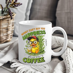 May include: White ceramic coffee mug with a cartoon duck wearing glasses and a cap, holding a coffee cup. The mug features the text "Money can't buy you happiness unless you are buying coffee."