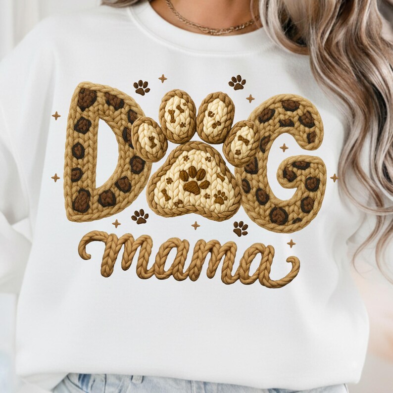 May include: White sweatshirt with a knitted design that says "Dog mama". The word "Dog" is spelled out with paw prints and a leopard print pattern. The word "mama" is in a cursive font.