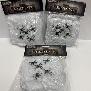 May include: Three identical clear plastic packages containing white synthetic spider web material and five small black plastic spiders. Each header card features the text HALLOWEEN, SPIDERS WEB, and 5 SPIDERS in a dark, weathered wood design.