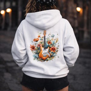 May include: White hoodie featuring a watercolor design of an electric guitar surrounded by orange, blue, and green flowers. The guitar has a brown body and neck with silver hardware. The hoodie is a casual garment.
