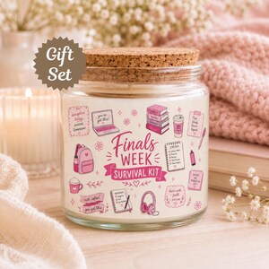 May include: A clear glass candle jar with a cork lid featuring a pink and white graphic print that reads Finals Week Survival Kit, surrounded by illustrations of a laptop, books, a coffee cup, a backpack, headphones, and study notes.