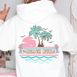 May include: A white ceramic mug with a black handle and the text "But First, Coffee" in a bold, black font. The mug is set against a blurred background, suggesting a cozy setting.