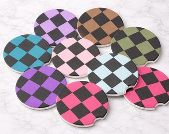 May include: A collection of nine circular car cup holder coasters, each featuring a distinct two-tone checkerboard pattern. The colors include purple, brown, olive green, teal, light pink, light blue, dark purple, hot pink, and magenta, all paired with black.