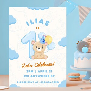 Op de afbeelding: Een lichtblauwe en witte verjaardagsuitnodiging met een cartoonbeer met een feesthoed en ballonnen. De uitnodiging luidt "Ilias is 1" en "Laten we vieren!" met datum, tijd en RSVP-informatie. Het ontwerp bevat blauwe wolken en het cijfer 1.