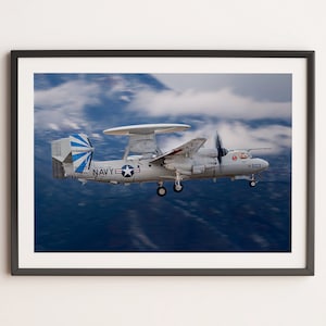 May include: A white and blue US Navy E-2C Hawkeye aircraft in flight against a blue sky with white clouds. The aircraft has a large radar dish on top and a distinctive tail design.