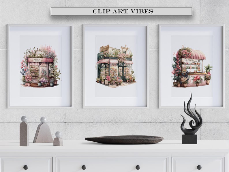 May include: Three framed watercolour paintings of pink floral shops with white trim and green plants. The paintings are hung on a grey concrete wall above a white shelf with three grey concrete sculptures and a black wooden tray.