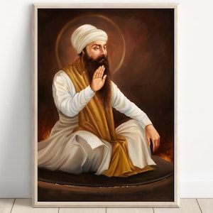 Op de afbeelding: Een ingelijst portret van een man met een lange baard en tulband, zittend in meditatie. Hij draagt witte en gouden kleding, met een gouden halo. De achtergrond is een warm, roodachtig bruin.