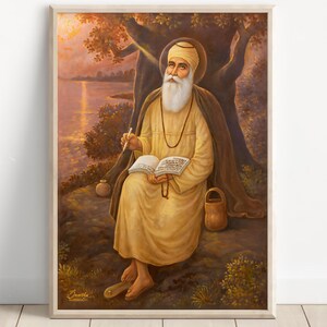 May include: Framed painting of a religious figure seated under a tree, writing in a book. The figure wears a yellow robe, a white turban, and has a long white beard. The background shows a lake and a sunset with warm colours.