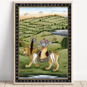 Puede incluir: Una impresión enmarcada de una pintura india tradicional. Una deidad de múltiples brazos monta un león a través de un paisaje verde. La deidad está adornada con joyas y una corona, sosteniendo un cuenco. El fondo presenta colinas, un río y una estructura distante.