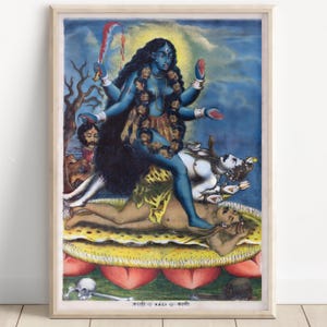 Puede incluir: Una impresión enmarcada de la diosa hindú Kali, representada con piel azul, múltiples brazos y una guirnalda de cabezas. Se encuentra sobre una figura, sosteniendo una espada y una cabeza cortada, sobre un fondo azul y amarillo.