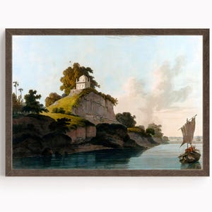 May include: A framed landscape print depicts a serene river scene. A small boat with a sail floats on the water. A white structure sits atop a hill, surrounded by trees and lush greenery. The sky is a mix of blue and white.