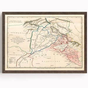 May include: A framed vintage map of the political divisions of the Punjab in 1846. The map features detailed geographical information with hand-drawn lines and text in various colors, including green, red, and blue. The map is encased in a dark brown wooden frame.