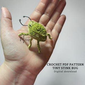 May include: A crocheted green stink bug with wire antennae and legs. The bug is held in a hand. Text on the image reads "CROCHET PDF PATTERN TINY STINK BUG Digital download".