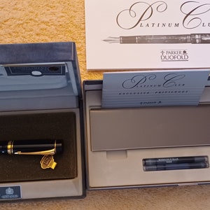 Puede incluir: Una pluma estilogr&aacute;fica Parker Duofold negra y dorada en su caja original. La pluma forma parte de la colecci&oacute;n Platinum Club. La caja incluye dos cartuchos de tinta.