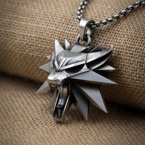 May include: A silver-colored pendant necklace featuring a stylized wolf head with sharp angles and open mouth. The pendant is attached to a chain necklace. The background is a textured, tan fabric.