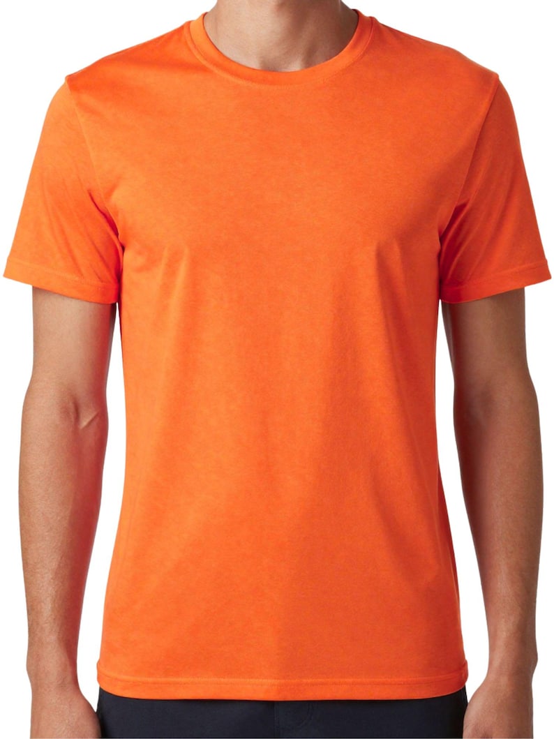 Puede incluir: Camiseta naranja brillante con cuello redondo. La camiseta de manga corta tiene un aspecto texturizado y un dise&ntilde;o cl&aacute;sico y sencillo. La camiseta est&aacute; hecha de un material ligero.