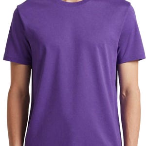 Puede incluir: Una camiseta lisa de color morado con cuello redondo. La parte superior de manga corta est&aacute; hecha de un material suave y tiene un dise&ntilde;o sencillo. La camisa es de un tono morado vibrante.