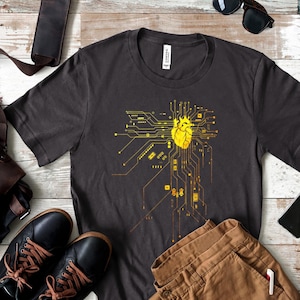 May include: A dark gray t-shirt with a yellow graphic of a heart inside a circuit board design.