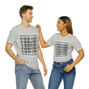 May include: Two people wearing grey t-shirts with the word "POSITIVE" printed in a repeating pattern. The text is in a gradient of grey shades, creating a 3D effect.