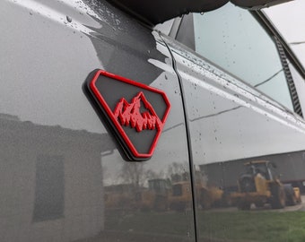 Par de insignias de guardabarros: Mountains, compatible con Bronco® Badlands® 2021+, rojo sobre negro mate