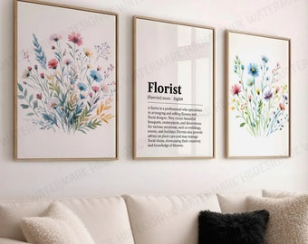 May include: Three framed prints featuring watercolour floral designs. The central print displays the word "Florist" with a definition. The prints are hung on a white wall above a white sectional sofa.