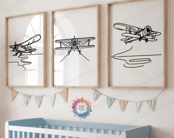 Pode incluir: Três desenhos em preto e branco de aviões em molduras numa parede branca. As molduras são de madeira e têm um passe-partout branco. Os aviões estão todos virados para a frente e têm as asas abertas. Os desenhos são simples e elegantes.