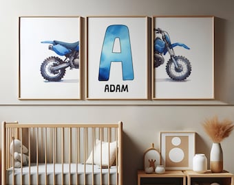 May include: Three framed wall art prints featuring a blue watercolor dirt bike on the left and right panels, and a large blue watercolor letter A with the name ADAM printed in black text below it on the center panel, all in light wood frames.
