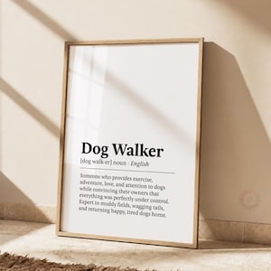 Könnte beinhalten: Ein gerahmter Kunstdruck mit einer wörterbuchartigen Definition des Begriffs Dog Walker. Der Text ist in Schwarz auf weißem Hintergrund gedruckt und beschreibt die Aufgabe, Hunden Bewegung, Abenteuer, Liebe und Aufmerksamkeit zu schenken.
