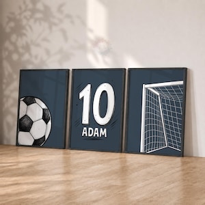 Puede incluir: Tres cuadros decorativos con fondo azul oscuro. El cuadro de la izquierda muestra un balón de fútbol en blanco y negro. El central presenta el número 10 grande en blanco sobre el nombre ADAM. El de la derecha muestra una red de portería.