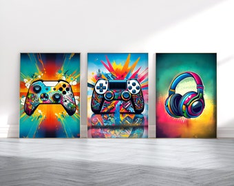May include: Three framed art prints featuring vibrant, colorful designs. The prints showcase a video game controller, another controller, and a pair of headphones. Each image has a dynamic, abstract background with bright colors like blue, orange, and pink.