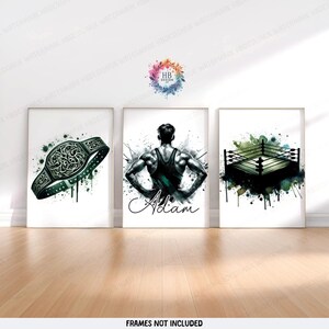 May include: Three framed art prints with a wrestling theme. The prints depict a championship belt, a muscular figure named "Adam", and a wrestling ring. Each print has a watercolour effect with green and black accents.