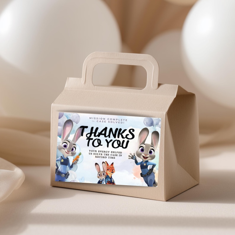 Puede incluir: Una caja de regalo beige con asa, con una pegatina colorida con el texto "THANKS TO YOU". La pegatina incluye im&aacute;genes de dibujos animados de conejos y zorros, con la frase "MISSION COMPLETE - CASE SOLVED!" y otro texto.