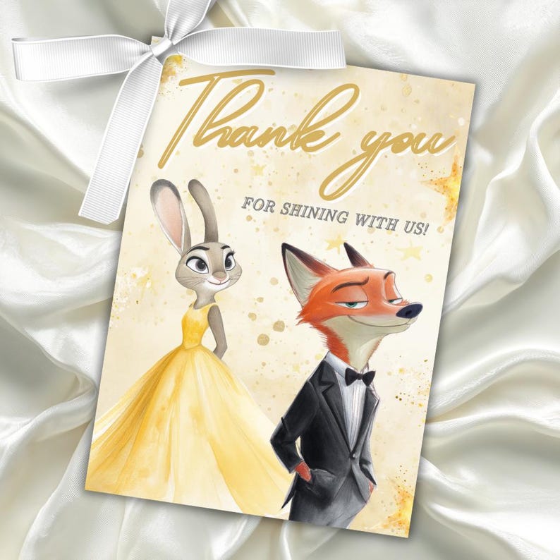 Puede incluir: Tarjeta de agradecimiento con Judy Hopps con un vestido amarillo y Nick Wilde con un esmoquin. El texto dorado dice "Thank you" y "For shining with us!". La tarjeta est&aacute; atada con una cinta blanca.
