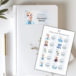 Könnte beinhalten: Weißes Notizbuch mit einem Etikett mit der Aufschrift "Dieses Buch gehört Veronika White" mit einem Cartoon-Bild einer Prinzessin. Ein Bogen mit individuellen Frozen-Buchnamensetiketten ist ebenfalls sichtbar.