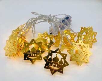 May include: A string of 10 gold star-shaped LED lights with a mosque design. The lights are battery-operated and perfect for Ramadan decorations.