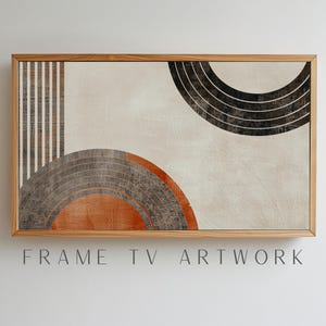 Op de afbeelding: Abstracte geometrische kunstprint met een houten lijst. De print heeft een witte achtergrond met overlappende cirkels in tinten oranje, grijs en zwart. De cirkels zijn omlijnd met dunne zwarte lijnen. De print is ingelijst in een natuurlijke houten lijst.