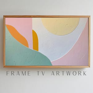 May include: Abstract art painting with a wooden frame. The painting features a mix of pink, yellow, orange, and green colors in a geometric pattern.
