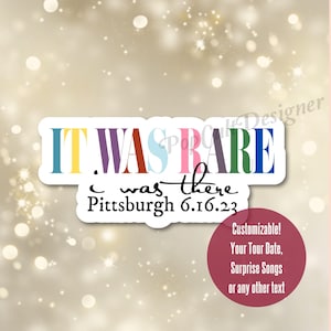 May include: A colorful sticker with the text "IT WAS RARE I WAS THERE Pittsburgh 6.16.23". The sticker is customizable with a tour date, surprise songs, or any other text.