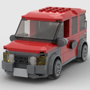 K&ouml;nnte beinhalten: Ein rotes Spielzeugauto mit einer grauen Frontsto&szlig;stange und schwarzen R&auml;dern. Das Auto hat eine klare Windschutzscheibe und einen schwarzen Innenraum.