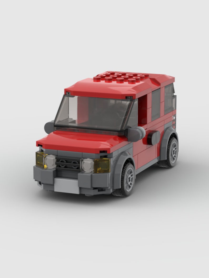 K&ouml;nnte beinhalten: Ein rotes Spielzeugauto mit schwarzen R&auml;dern und einer grauen Frontsto&szlig;stange. Das Auto hat eine klare Windschutzscheibe und schwarze Seitenfenster.
