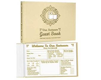May include: A beige guest book titled "Our Restroom Guest Book" with a decorative toilet paper roll graphic. The open book reveals fill-in-the-blank prompts for guests. The cover text reads "Something to do while you do what you do."