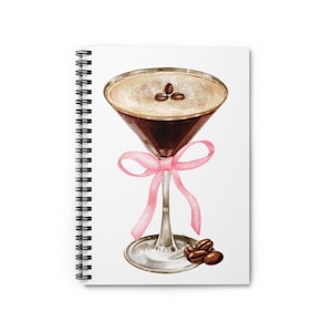 May include: A watercolor illustration of a coffee martini with a pink ribbon tied around the stem. The martini glass is filled with a dark brown liquid and topped with a layer of white foam. Three coffee beans are visible on top of the foam. Three coffee beans are scattered on the white background.
