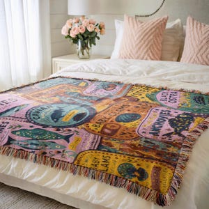 Vintage-style woven tapestry blanket featuring colorful sardine, anchovy, caviar, and clam labels in a collage design.  Blanket is being shown as bedding