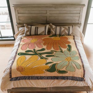 Boho flower woven blanket with vintage large floral design in earthy tones.  Showns 4 large flowers in retro style design in earth tone colors.  Perfect as  tapestry, throw for sofa, bed, or wall hanging,  Beige color shown here being used as bed spread.
