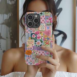 May include: A smartphone case featuring a colorful collage of floral patterns, checkered squares, and inspirational text notes including You Are Enough Just As You Are, Don't Forget How Amazing You Are, It's Okay To Take A Break, Believe Yourself, and You Matter.