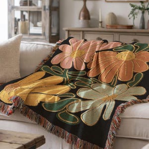 Boho flower woven blanket with vintage large floral design in earthy tones.  Showns 4 large flowers in retro style design in earth tone colors.  Perfect as  tapestry, throw for sofa, bed, or wall hanging,  Black color shown here as a sofa throw.