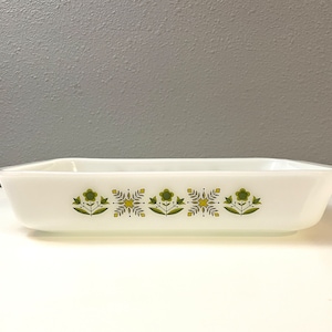 May include: White rectangular baking dish with a green and yellow floral design. The dish has a slightly rounded rim.
