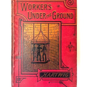 May include: A red book with the title "Workers Under the Ground" and the author's name "Hartwig" on the cover. The cover features an illustration of a mine shaft with workers in a cage.