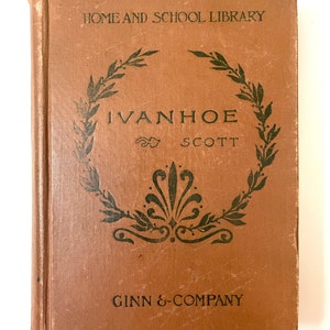 May include: A brown book with the title "Ivanhoe by Scott" on the cover. The book is part of the "Home and School Library" series and is published by Ginn & Company.