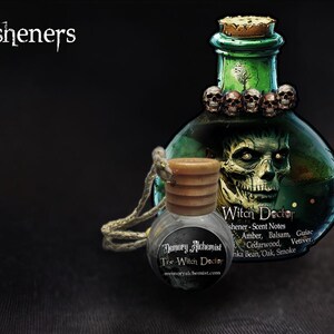 May include: A small glass bottle with a wooden cap and a black and white label that reads "The Witch Doctor" hanging from a string. The bottle is filled with a clear liquid. The bottle is in front of a larger glass bottle with a green liquid and a skull design. The larger bottle has a label that reads "Witch Doctor" and lists scent notes.
